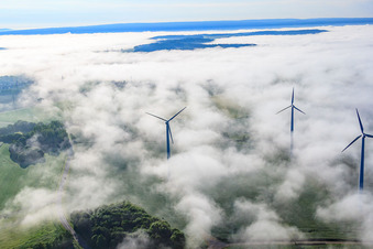 Luftaufnahme von Rotoren des Windpark Fürstenau ragen aus tiefen Wolken heraus in Höxter im Bundesland Nordrhein-Westfalen, Deutschland