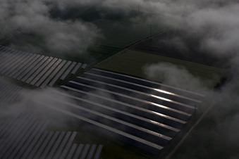 Wetterbedingt in eine Nebel- Schicht eingebettete Panelreihen der Photovoltaikanlage des Solarpark bzw. Solarkraftwerk im Ortsteil Bredenborn in Marienmünster im Bundesland Nordrhein-Westfalen, Deutschland von oben