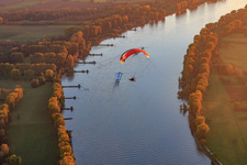 Nato-Rampe Gernsheim mit Paraglider über Frachtschiff auf dem Rhein beim Sonnenuntergang im Bundesland Hessen, Deutschland