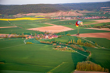 Gleitschirm über dem Ort im Ortsteil Wiebelsberg in Oberschwarzach im Bundesland Bayern, Deutschland