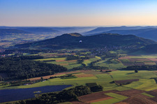 Heißluftballon im Morgendunst der Fränkischen Schweiz in Fahrt über dem Luftraum im Ortsteil Schlaifhausen in Wiesenthau im Bundesland Bayern, Deutschland