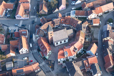 Gebäude der von einem Häuserring umgebenen lutherisch-protestantischen Wehrkirche im Dorfkern in Dossenheim-sur-Zinsel in Grand Est im Bundesland Bas-Rhin, Frankreich aus der Vogelperspektive