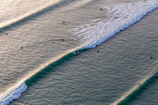 Luftaufnahme von Wellensurfer vor dem Plage de Tronoën in Saint-Jean-Trolimon im Bundesland Finistère, Frankreich