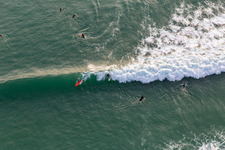 Wellensurfer vor dem Plage de Tronoën in Saint-Jean-Trolimon im Bundesland Finistère, Frankreich von oben gesehen