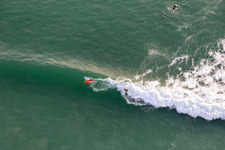 Wellensurfer vor dem Plage de Tronoën in Saint-Jean-Trolimon im Bundesland Finistère, Frankreich aus der Vogelperspektive