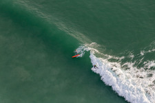 Drohnenaufname von Wellensurfer vor dem Plage de Tronoën in Saint-Jean-Trolimon im Bundesland Finistère, Frankreich