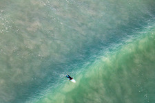 Drohnenbild von Wellensurfer vor dem Plage de Tronoën in Saint-Jean-Trolimon im Bundesland Finistère, Frankreich
