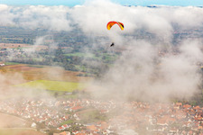 Luftbild von Ortschaft mit Gleitschirm unter herbstlichen Wolken in Steinweiler im Bundesland Rheinland-Pfalz, Deutschland