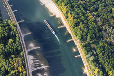 Leeres Frachtschiff bei Niedrigwasser am Rhein zwischen Hördter Rheinaue und Dettenheim im Bundesland Rheinland-Pfalz, Deutschland