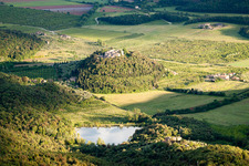 Dorf - Ansicht auf einem bewaldeten, runden Hügel mit See im Ortsteil Poggio Santa Cecilia in Rapolano Terme im Bundesland Siena, Italien