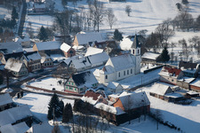 Winterlich schneebedeckte Kirchengebäude im Dorfkern in Eberbach-Seltz in Grand Est im Bundesland Bas-Rhin, Frankreich