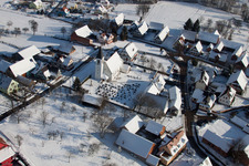 Schrägluftbild von Winterlich schneebedeckte Kirchengebäude im Dorfkern in Eberbach-Seltz in Grand Est im Bundesland Bas-Rhin, Frankreich