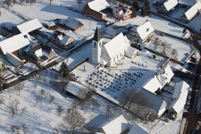 Winterlich schneebedeckte Kirchengebäude im Dorfkern in Eberbach-Seltz in Grand Est im Bundesland Bas-Rhin, Frankreich von oben