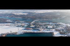Winterlich schneebedeckte Gebäude und Produktionshallen auf dem Werksgelände des Chemieproduzenten DOW France S.A.S. am Rheinufer in Lauterbourg in Grand Est im Bundesland Bas-Rhin, Frankreich