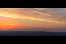 Sonnenuntergang färbt den Himmel überder Schwäbischen Alb rot orange in Hayingen im Bundesland Baden-Württemberg, Deutschland